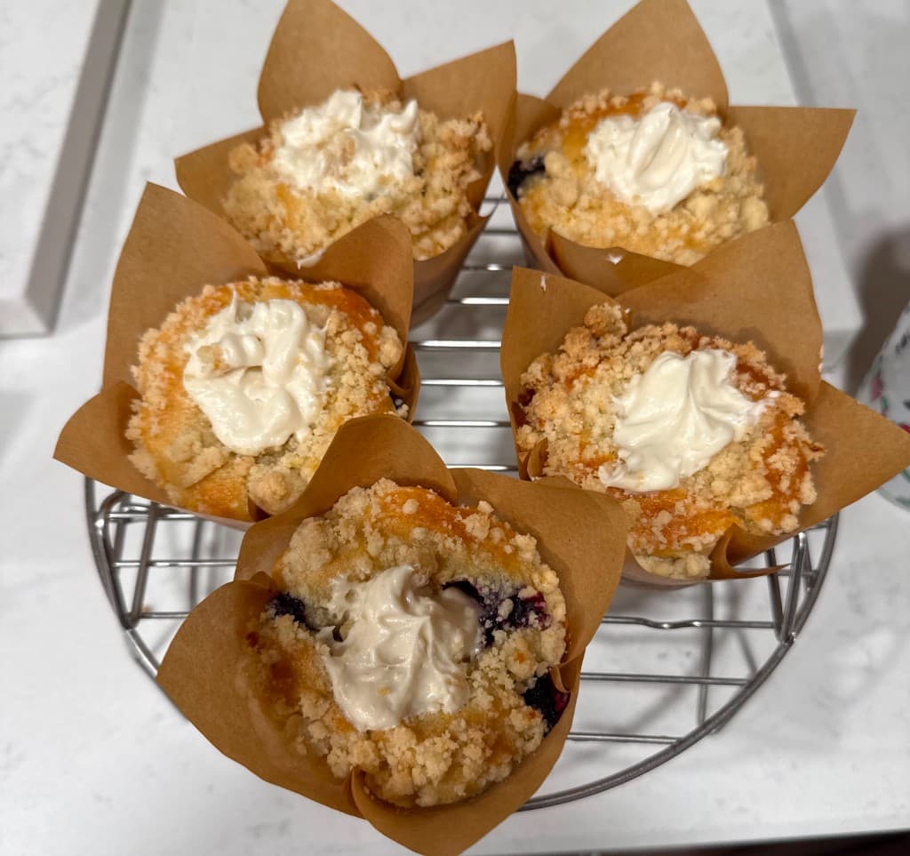Fresh blueberry muffins with cream on a cooling rack